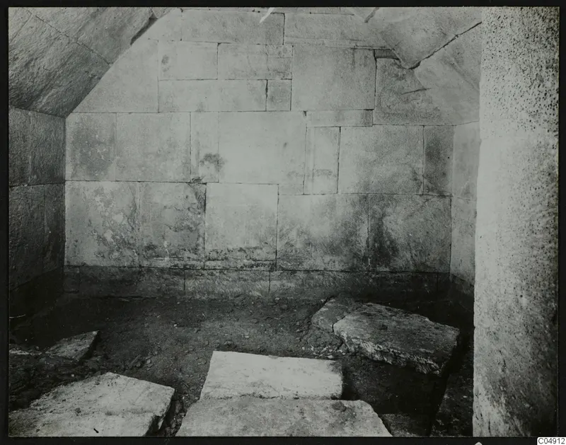 Interior of Tomb 2 at Amathus, showing large stone-block walls and a curved stone ceiling.