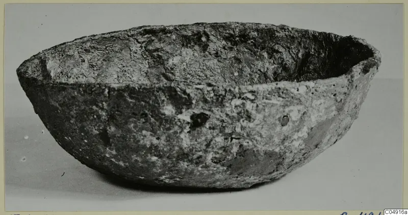 Encrusted bowl with a rounded body and flared rim, photographed on a plain background from Enkomi