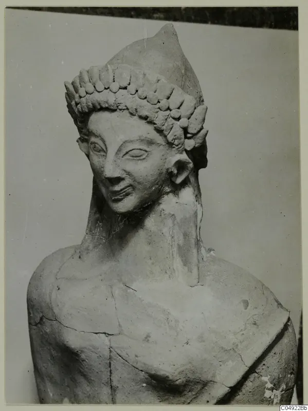 Terracotta head and upper body of a figure with a tiered headdress of rounded knobs, from Mersinaki