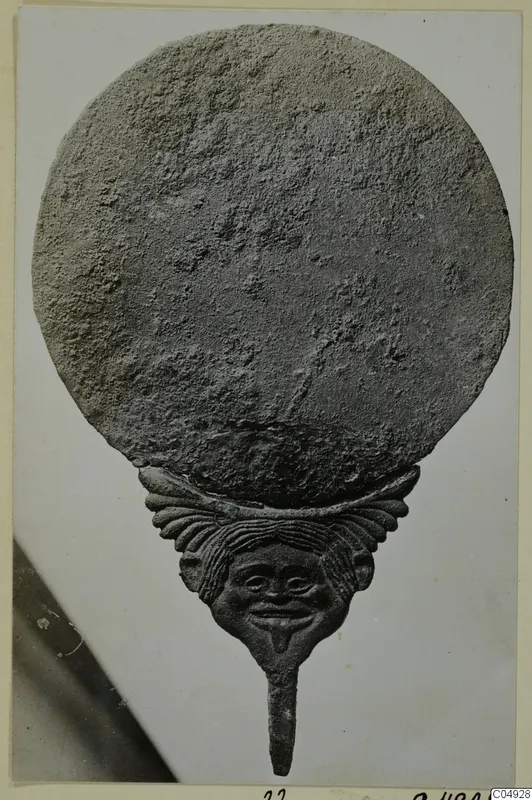 Round plate above a face-shaped figure with a long stem, from Marion