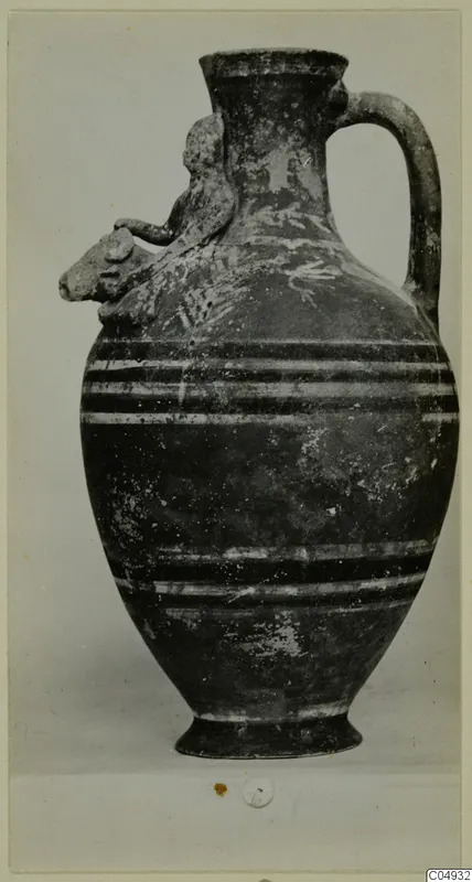 Jug from Marion with a modelled animal head on the shoulder, a strap handle and dark bands around the body