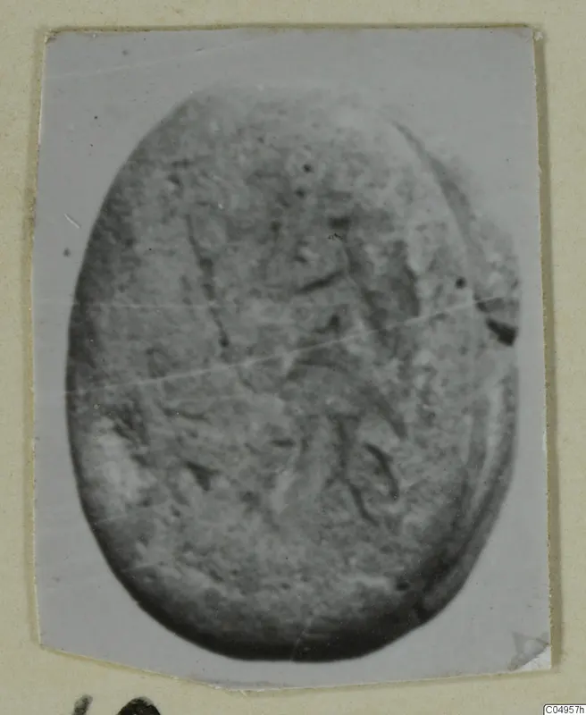 Oval engraved seal or gem from Amathus, shown in a close-up photograph with a faint carved design.