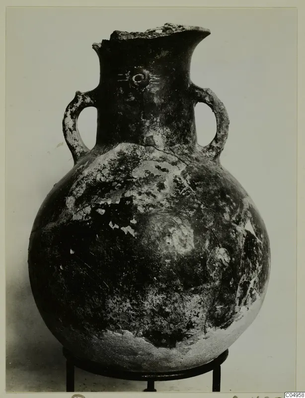 Red Polished II amphora from Lapithos, globular with two loop handles and a broken rim, shown on a stand
