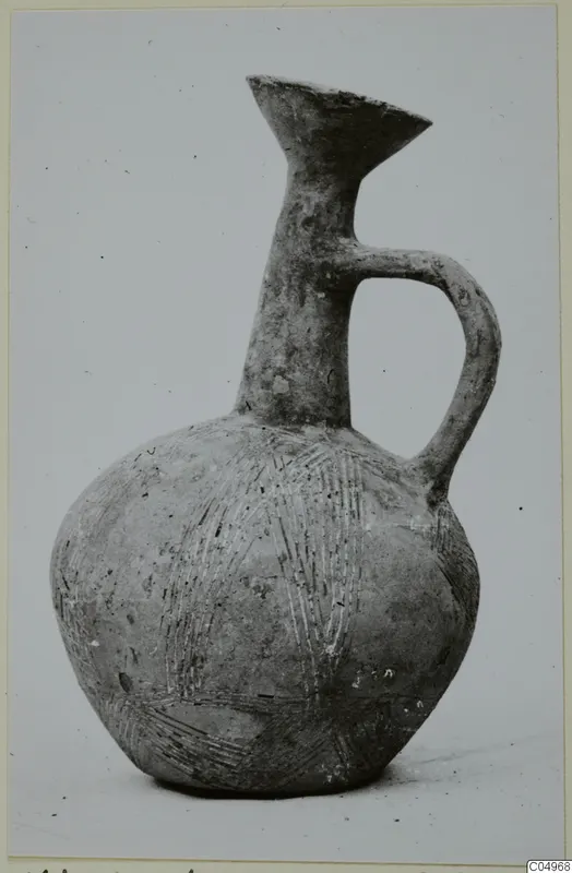 Pottery Black Slip Ware jug from Milia with a single loop handle and incised lines on its body
