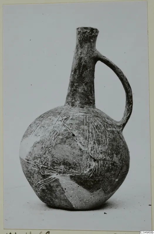 Black Slip Ware jug from Milia with a tall narrow neck and a single loop handle, decorated with linear bands