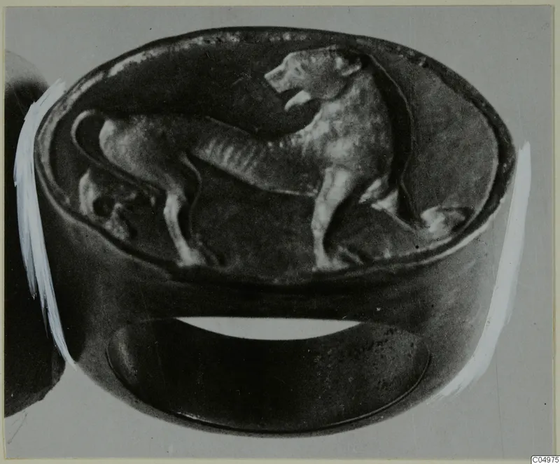 Ring with an oval bezel carrying a standing four-legged animal figure in relief.
