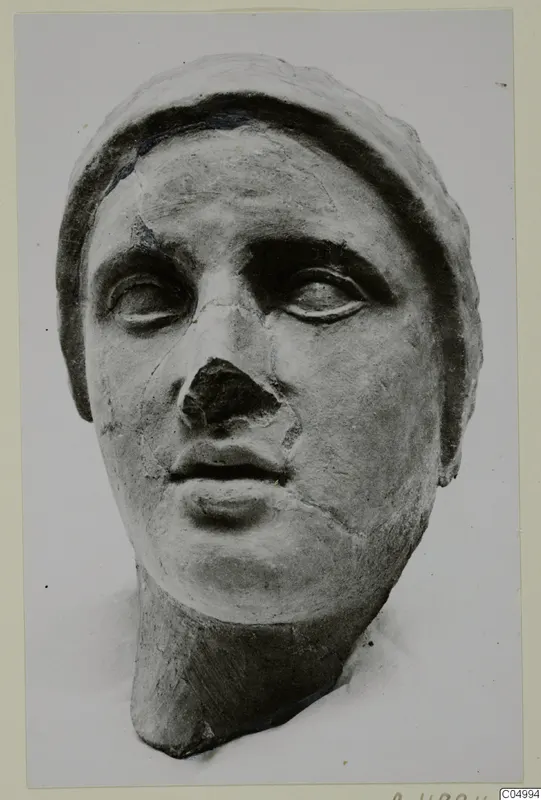 Sculpted head from Mersinaki with a broken nose and a wide band framing the head.
