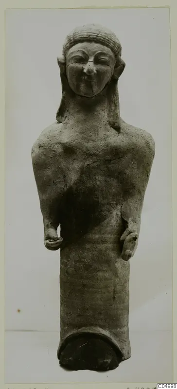 Terracotta Cypro-Greek I figure from Mersinaki, standing on a cylindrical base, photographed against a plain grey background