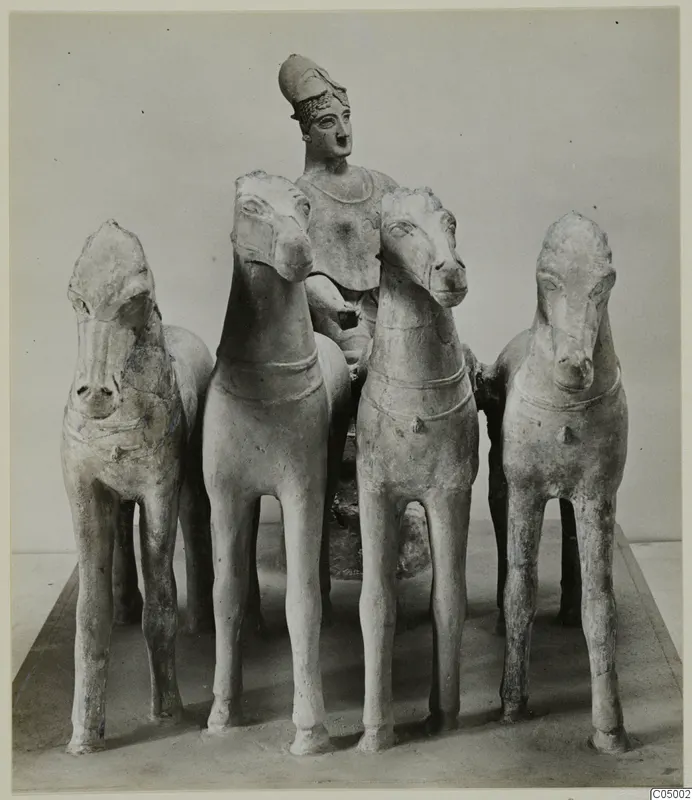 Terracotta group of four horses with a helmeted figure standing behind them