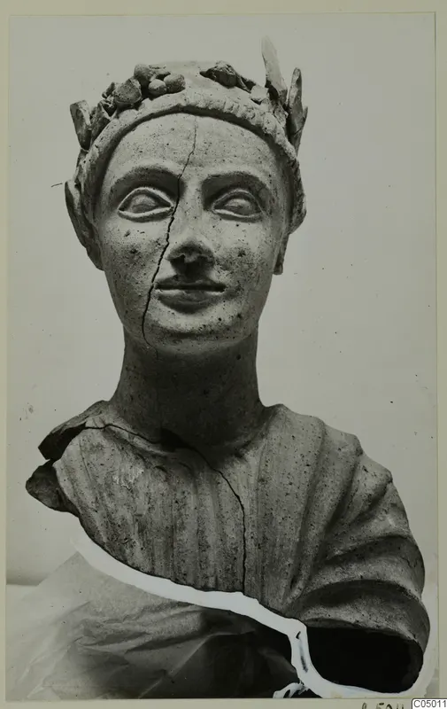 Terracotta bust of a figure wearing a leafy wreath, with a crack running down the face and neck
