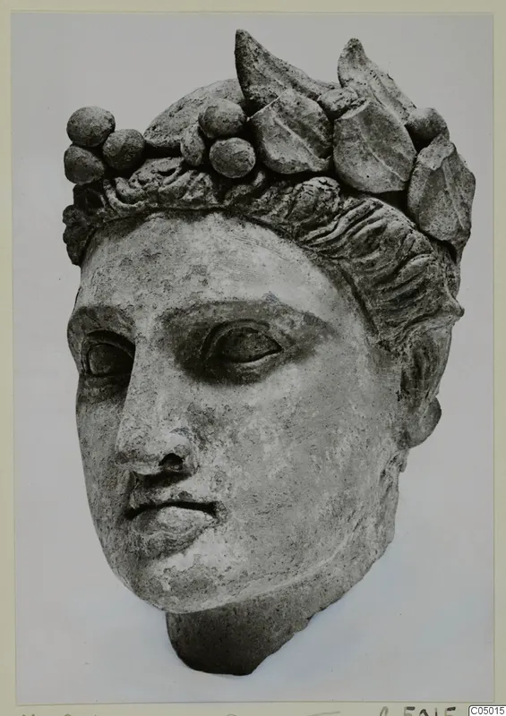 Stone head of a statue from Mersinaki, wearing a wreath of leaves and round berries in its hair.