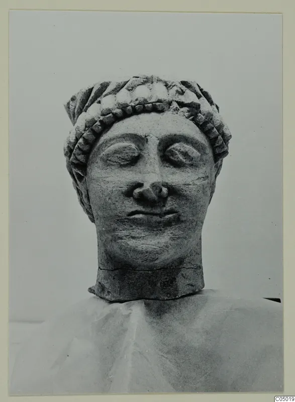 Limestone head from Mersinaki with downcast eyes and a band of curled hair across the brow