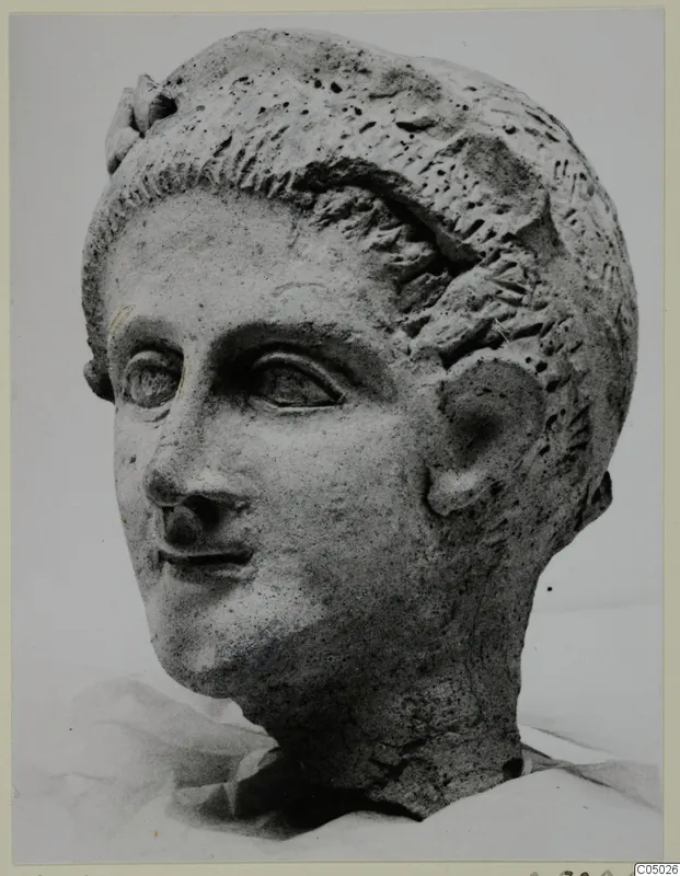Head of a sculpture from Mersinaki, a male or youthful face with short hair, shown in a photograph against a pale background.