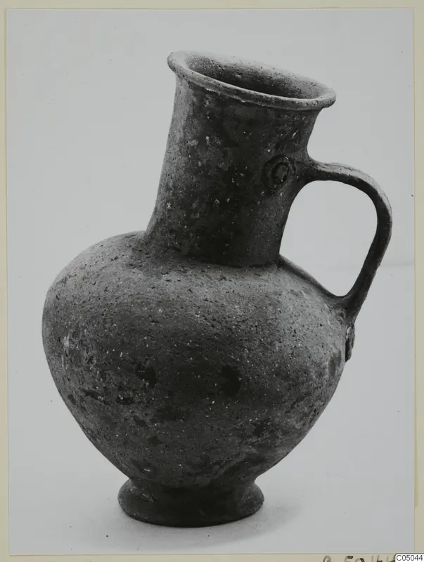 Pottery Base-Ring Ware jug with a single strap handle and flaring rim.