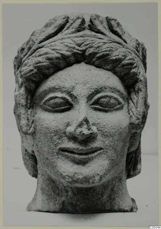 Limestone head of a bust with curled hair and a smiling face, from Mersinaki