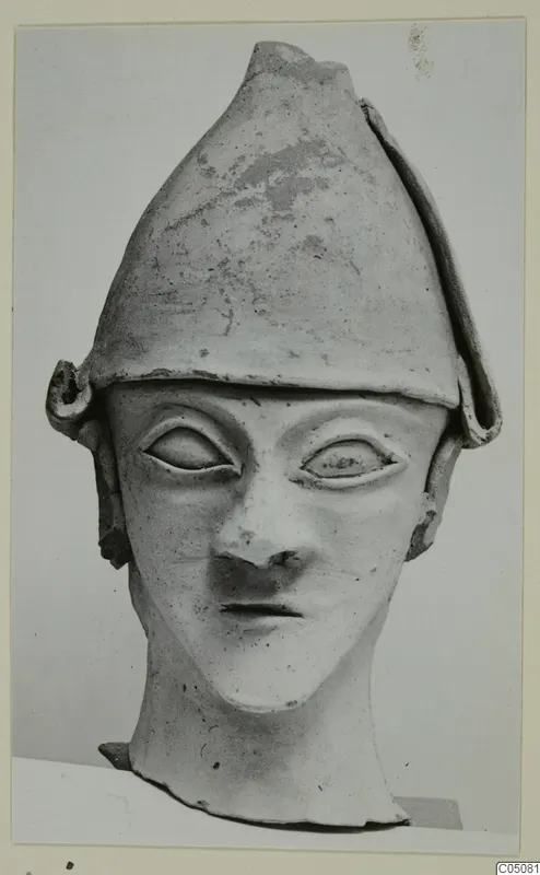 Terracotta head from Ayia Irini with a tall conical cap, large almond-shaped eyes and a long neck