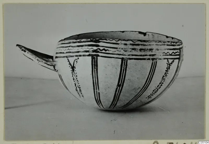 Bowl with a long projecting handle, painted with black bands, wavy lines and vertical stripes; Enkomi find photograph