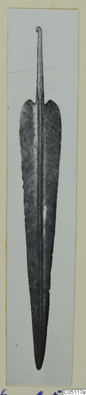 Metal weapon blade with a central ridge, leaf-shaped edges and a narrow tang with a curled end