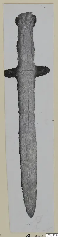Iron dagger with a short crossguard and pointed tip, photographed upright on a pale mounted card