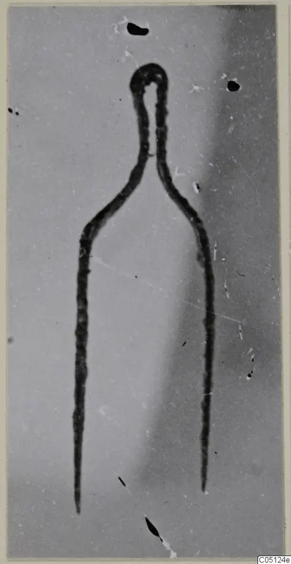 Bronze tweezers from the Kastros tombs at Lapithos, shown as a dark outline against a grey background