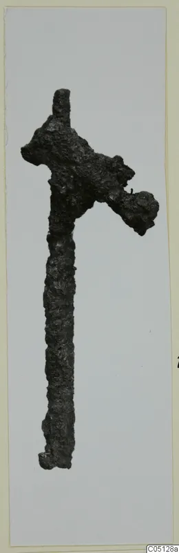 Corroded iron axe with a long shaft, from the Kastros tombs at Lapithos