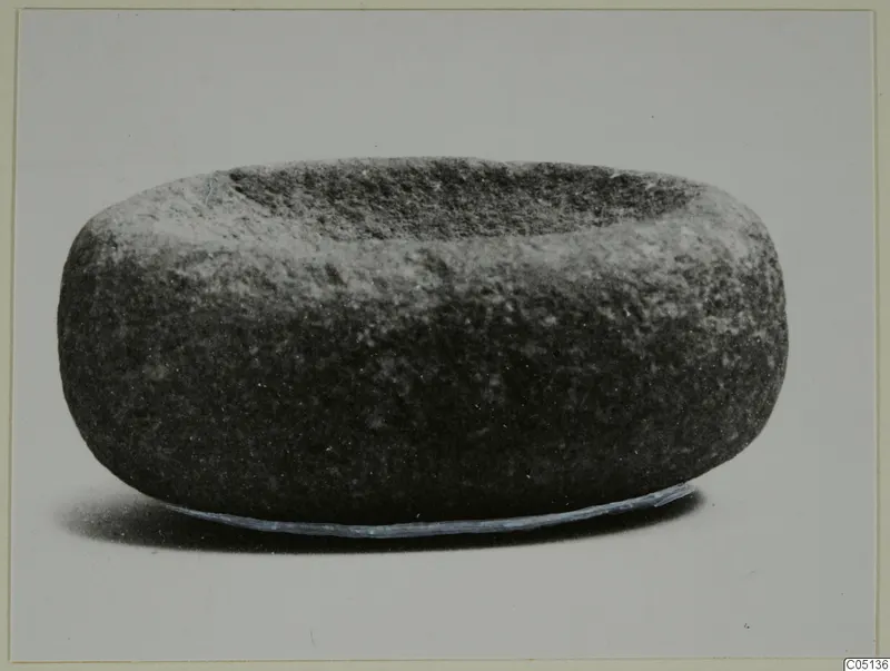 Stone mortar from Petra tou Limniti, squat and rounded, with a shallow hollow in its top.