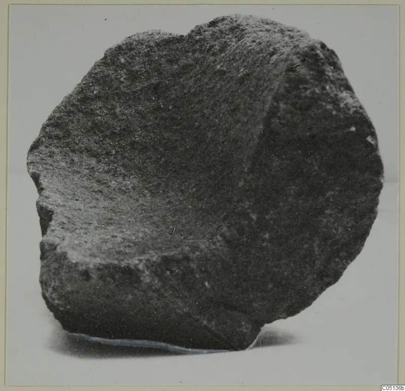 Fragment of a stone mortar from Petra tou Limniti, shown from the side against a pale background