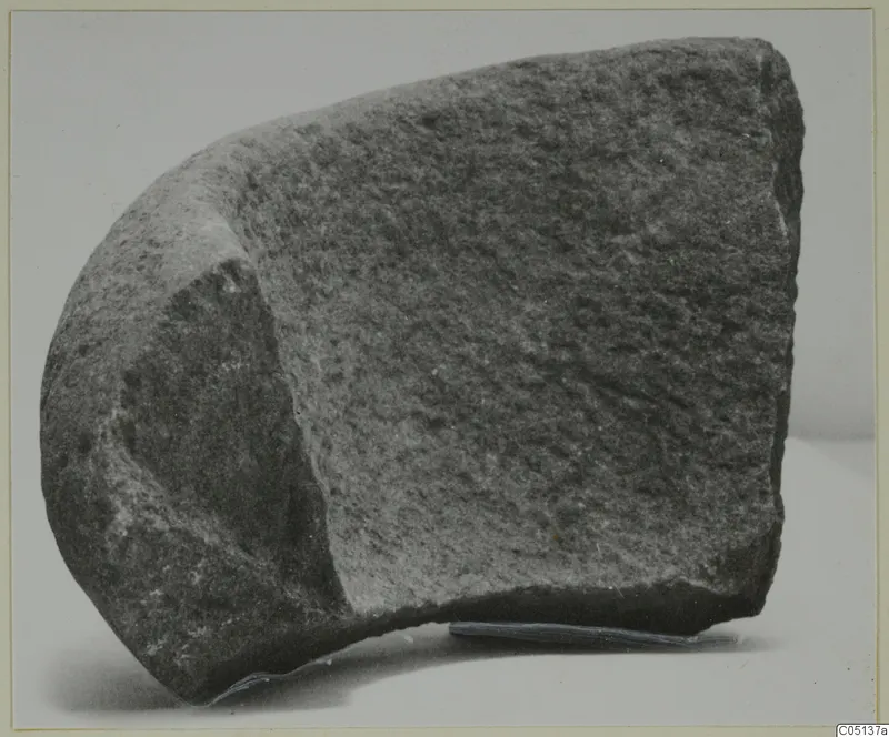 Fragment of stone from Petra tou Limniti, shown on a plain background with a rounded outer face and a flatter dressed face.