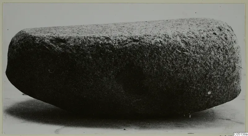 Stone object from Petra tou Limniti, an elongated block with rounded ends, photographed on a pale surface.