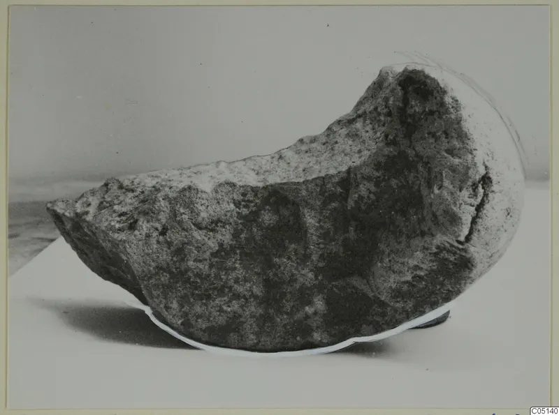 Fragment of a stone bowl from Petra tou Limniti, shown in side view on a pale surface.