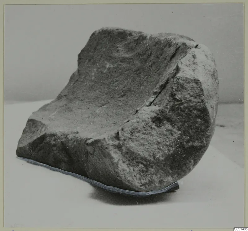 Large stone mortar from Petra tou Limniti, a rough block with a deep hollow worn into its upper face.