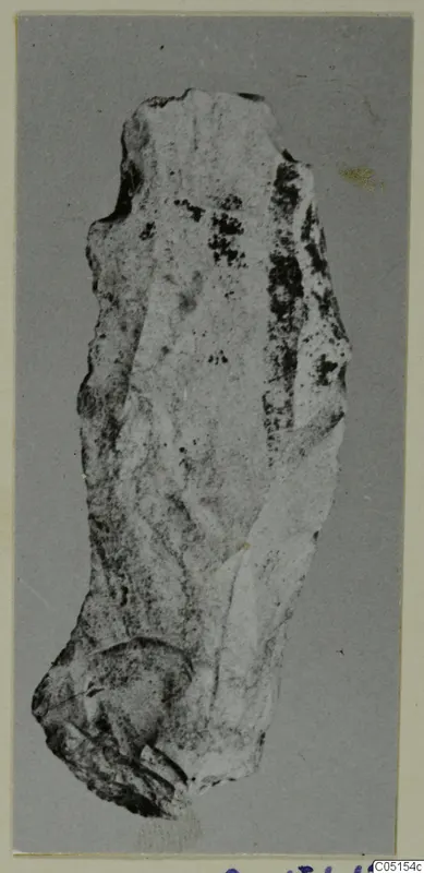Knife of stone from Petra tou Limniti, photographed upright on a grey mount