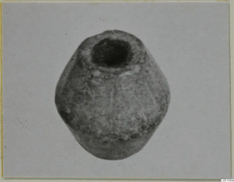 Stone object with a wide circular opening at the top, photographed alone against a pale background.
