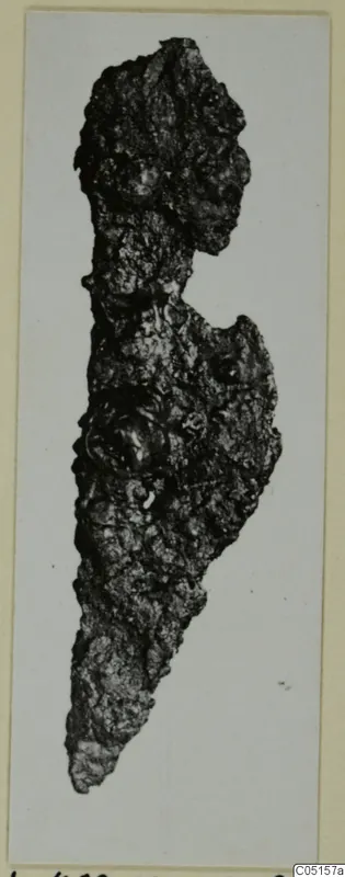 Corroded iron knife from the Kastros tombs at Lapithos, shown on a card mount.