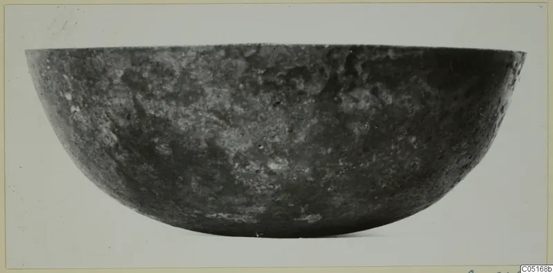 Dark, mottled bowl photographed in side view, a find from the Kastros tombs at Lapithos
