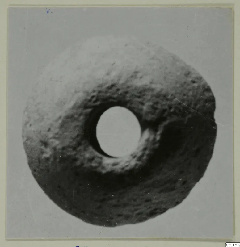 Terracotta ring-shaped object with a large central hole, shown from above against a plain grey background