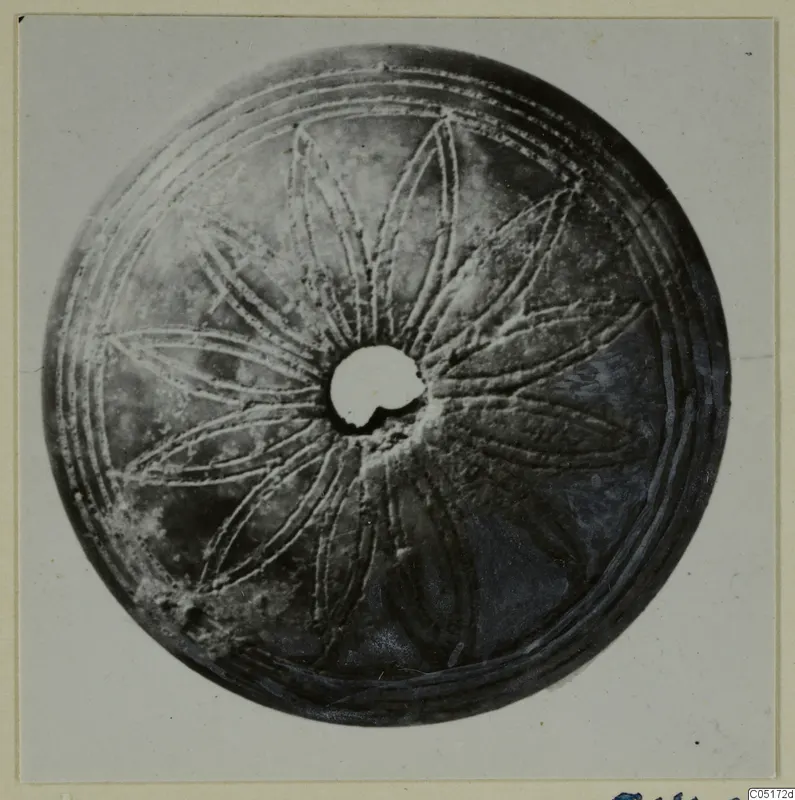 Round bone disc with a central hole and incised radiating petal-like pattern, from the Kastros tombs at Lapithos