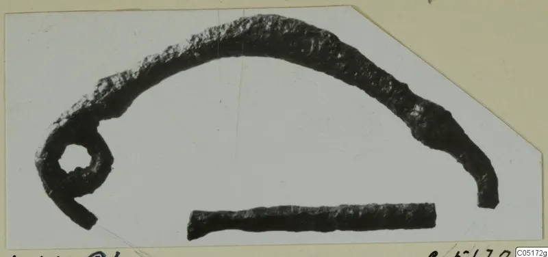 Corroded bronze loop with a curved arm, and a separate short bronze rod, from the Lapithos Kastros tombs finds