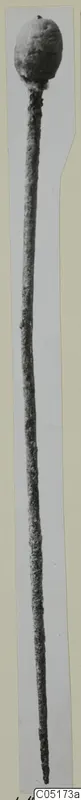 Long bronze pin with a rounded head, photographed against a plain background.