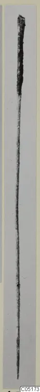Long slender metal object with a thicker rounded top tapering to a point, shown upright on a grey background