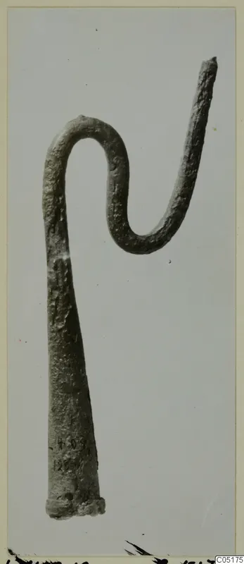 Bronze crook-shaped tool from Lapithos, Kastros tombs, photographed against a plain grey background