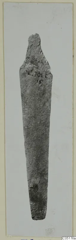 Bronze knife blade from Lapithos, Vrysi tou Barba tombs, photographed upright with a handwritten number label