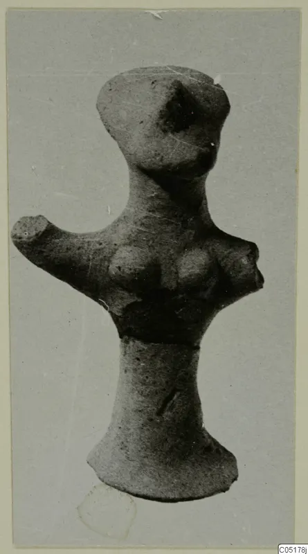 Terracotta figurine with a rounded head, an arm projecting to the left and a flared base, photographed on a grey card mount