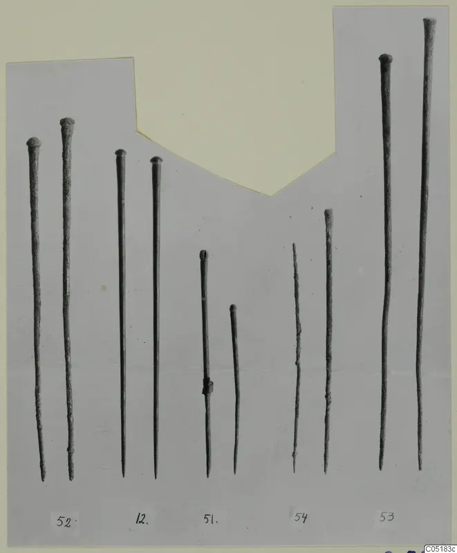 Ten long, thin metal tools with knobbed heads, laid side by side in a row.