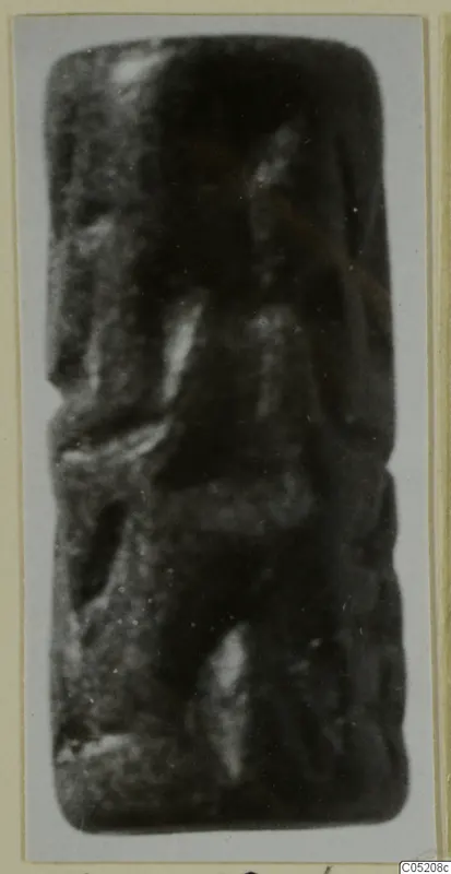 Cylinder seal from Enkomi, photographed upright on a grey card; the carved surface is blurred