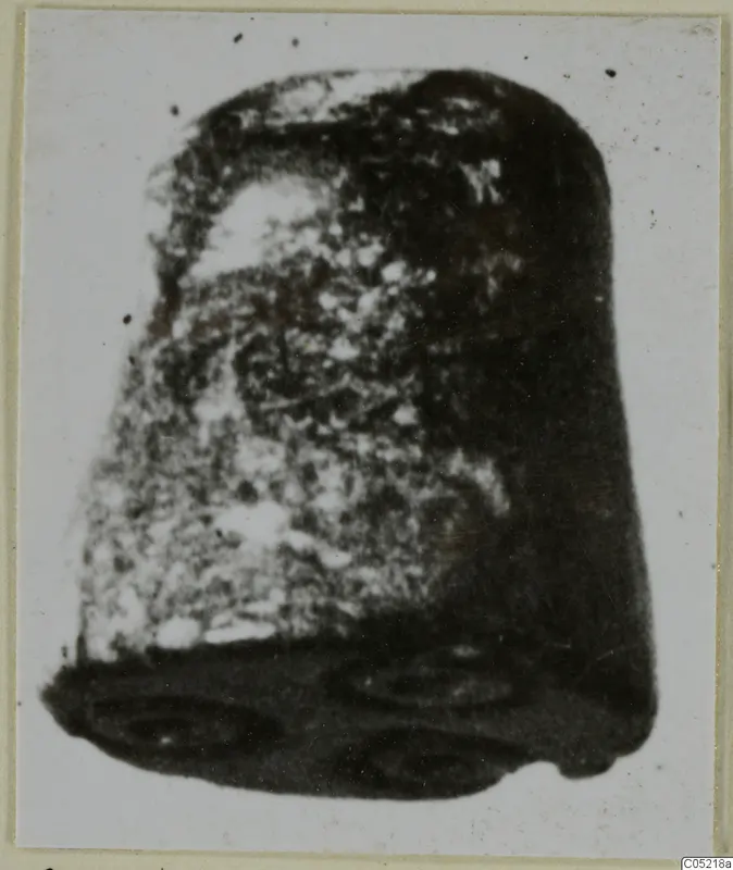 Cylinder seal in stone, photographed close up against a pale background