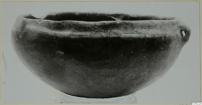 Pottery Black Slip Ware bowl with a rounded body and a small handle on one side