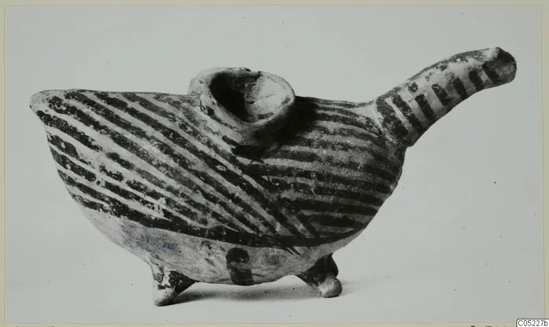 Painted pottery vessel with a long spout, a collar-shaped opening and three legs, decorated with dark diagonal bands