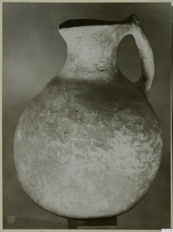 Pottery jug with a globular body, tall neck and strap handle, from the Vrysi tou Barba tombs at Lapithos