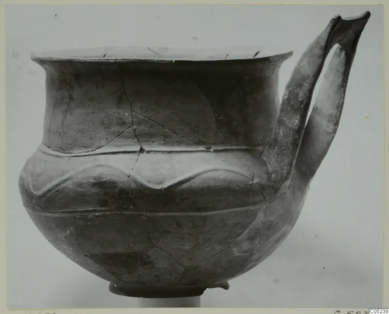 Pottery Base-Ring Ware crater with a flared rim, a wavy relief band and a tall strap handle